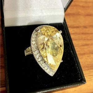 This bling ring is massive!  Yellow stone probably 25 carats. Rhinestones silver
